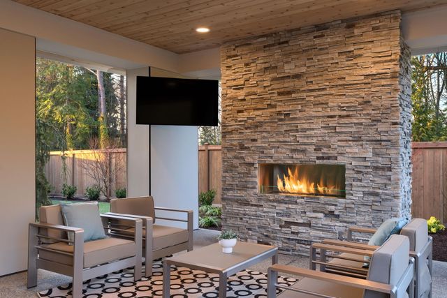 Outdoor living room with stone fireplace and seating